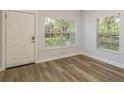 Bright entryway featuring wood-look floors, two large windows offering plenty of natural light, and a white front door at 3583 Wembley Way # 101, Palm Harbor, FL 34685