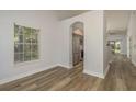 Open-concept living room showcasing wood-look floors, access to the kitchen, and plenty of natural light at 3583 Wembley Way # 101, Palm Harbor, FL 34685