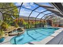 Sparkling pool with a spa and waterfall feature, surrounded by lush tropical landscaping at 5416 Twin Creeks Dr, Valrico, FL 33596