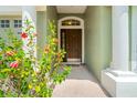 Close-up of front door with decorative columns and vibrant flowers, creating an inviting entrance at 5902 War Admiral Dr, Wesley Chapel, FL 33544