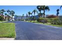 Exterior view of condos with palm trees, showcasing the community's landscaping and parking area at 719 Pinellas Bayway S # 309, Tierra Verde, FL 33715