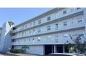 Low angle view of the condo building featuring multiple stories with balconies and ground-level parking at 719 Pinellas Bayway S # 309, Tierra Verde, FL 33715
