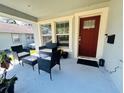 Cozy front porch with stylish seating, a red front door, and ample natural light, perfect for relaxing outdoors at 724 15Th S Ave, St Petersburg, FL 33701