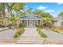 Charming home featuring a landscaped yard, brick walkway, and covered front porch at 7708 N Arden Ave, Tampa, FL 33604