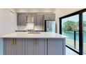 Modern kitchen featuring stainless steel appliances, gray cabinets, quartz countertops, and a scenic view at 772 Gran Kaymen Way, Apollo Beach, FL 33572