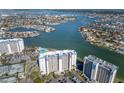 Elevated view of the condo building and surrounding waterfront featuring a pool and ample parking at 9525 Blind Pass Rd # 508, St Pete Beach, FL 33706