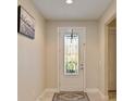 Bright foyer with decorative front door featuring patterned glass, adjacent to walls in neutral color with decorative wall art at 10404 Scarlet Chase Dr, Riverview, FL 33569