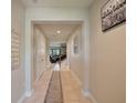 Inviting hallway with neutral tones, tiled floors, and staircase view to the living area at 10404 Scarlet Chase Dr, Riverview, FL 33569
