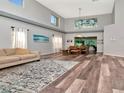 Spacious living room and dining area with tall ceilings, modern light fixture, and hardwood floors at 10501 Dotham Ct, Tampa, FL 33626