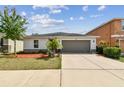 Well-maintained single-story home features a two-car garage, front yard with attractive landscaping at 10603 Massimo Dr, Wimauma, FL 33598