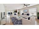 Open-concept living room with hardwood floors, a ceiling fan, and lots of natural light at 13622 Tramore Dr, Odessa, FL 33556