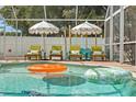 Inviting screened-in pool area with lounge chairs and umbrellas for relaxing and enjoying the outdoors at 1698 Eden Ct, Clearwater, FL 33756