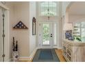 Inviting foyer features a high ceiling, shuttered windows, and elegant decor, creating a welcoming entrance at 18106 Woodcreek Pl, Lutz, FL 33548