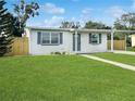 Inviting single story home boasts a lush front lawn, carport and fresh exterior paint at 21042 Gladis Ave, Port Charlotte, FL 33952