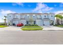 Street view of modern light-blue townhomes, showcasing driveways, lawns, and simple landscaping at 2265 Alee Ln, Wesley Chapel, FL 33543