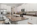 Bright kitchen with granite countertops, white cabinets, stainless appliances, and a breakfast bar at 2835 Hilliard Dr, Wesley Chapel, FL 33543