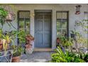 Charming front door with sidelight windows and potted plants surrounding the entry at 3721 140Th Ave, Largo, FL 33771