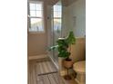 Bright bathroom featuring a glass-enclosed shower, tiled floors, and a large window at 4053 Rocky Shores Dr, Tampa, FL 33634