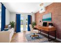 Bright home office with exposed brick wall, walk-out to garden and neutral color accents at 4732 W Wyoming Ave, Tampa, FL 33616