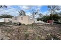 Exterior view of a partial demolition of a home surrounded by overgrown yard at 512 Carolyne St, Temple Terrace, FL 33617