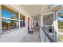 Exterior hallway with painted concrete walls, white railings, and multiple red entrance doors at 5150 10Th N Ave # 310A, St Petersburg, FL 33710