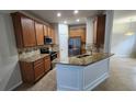 Well-lit kitchen featuring granite countertops, stainless steel appliances, and wooden cabinets at 7530 Red Mill Cir, New Port Richey, FL 34653
