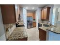 Updated kitchen featuring stainless steel refrigerator, granite countertops, and tile backsplash at 7530 Red Mill Cir, New Port Richey, FL 34653