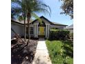 Charming home featuring a bright yellow front door flanked by white columns and a well-manicured lawn at 824 Greenbelt Cir, Brandon, FL 33510
