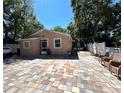 A spacious backyard features patterned tile flooring, and wicker chairs; great for entertaining and relaxation at 8516 N Dixon Ave, Tampa, FL 33604