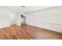 Well-lit room with wood-look flooring, large windows with shutters, and a neutral color palette at 8801 Gulf Blvd, St Petersburg, FL 33706