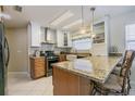 Bright kitchen featuring an island, granite countertops, stainless appliances, and modern cabinetry at 965 Westwinds Blvd, Tarpon Springs, FL 34689