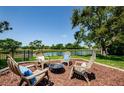 Relaxing backyard view featuring a pond and outdoor seating around a fire pit at 10600 Indian Hills Ct, Seminole, FL 33777