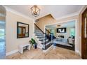 Beautiful foyer with tile floors, stairs, and an entrance to the living room and a mirror at 10600 Indian Hills Ct, Seminole, FL 33777