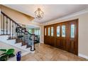 Elegant foyer with tile flooring, a wooden staircase, and a decorative front door at 10600 Indian Hills Ct, Seminole, FL 33777