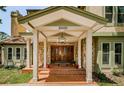 Inviting front porch featuring a stone facade, brick steps, and double front doors at 10600 Indian Hills Ct, Seminole, FL 33777