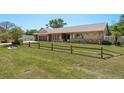 Charming home exterior featuring a brick driveway, stone accents, and attractive wood fence at 113 Garland Cir, Palm Harbor, FL 34683
