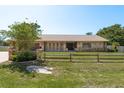 Charming home exterior featuring a brick driveway, stone accents, and attractive wood fence at 113 Garland Cir, Palm Harbor, FL 34683