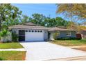 Charming one-story home with manicured lawn, featuring a two-car garage and mature trees in a suburban setting at 12536 116Th St, Largo, FL 33778