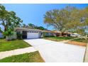 Charming one-story home featuring a well-maintained lawn and a spacious driveway leading to a two-car garage at 12536 116Th St, Largo, FL 33778