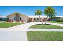 Charming home featuring a well-maintained lawn, decorative plantings, and a spacious driveway for ample parking at 13797 Pinecrest Dr, Largo, FL 33774