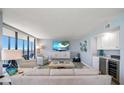 Bright living room features a modern entertainment center, a wet bar with wine fridge, and ocean views at 15462 Gulf Blvd # 904, Madeira Beach, FL 33708