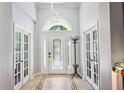 Bright foyer with tiled floors, high ceilings, decorative chandelier, and double doors to other rooms at 15930 Sorawater Dr, Lithia, FL 33547