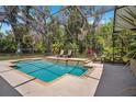 Inviting screened-in pool area with a waterfall feature and poolside seating; great backyard retreat at 15930 Sorawater Dr, Lithia, FL 33547
