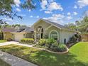 Charming single-story home with beautifully maintained landscaping, including bushes and manicured lawn at 16608 Meadow Cove St, Tampa, FL 33624