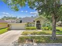 Charming single-Gathering home boasts lush front yard landscaping and a convenient two-car garage at 16608 Meadow Cove St, Tampa, FL 33624