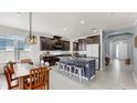 Open-concept kitchen featuring dark cabinets, a large island, and a dining area at 17740 Bright Wheat Dr, Lithia, FL 33547