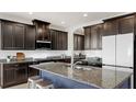 Modern kitchen features stainless appliances, granite countertops, and an island with seating at 17740 Bright Wheat Dr, Lithia, FL 33547