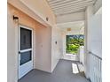 Condo hallway entrance featuring an exit and view of lush green trees, inviting residents to a peaceful outdoor setting at 2291 Americus W Blvd # 41, Clearwater, FL 33763