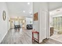 Bright, open-concept living space with hardwood floors, dining area, comfortable seating, and a bathroom to the side at 2291 Americus W Blvd # 41, Clearwater, FL 33763