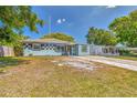 Charming single-story home featuring a colorful facade, brick walkway, and well-maintained landscaping at 3045 Stratford Dr, Largo, FL 33771